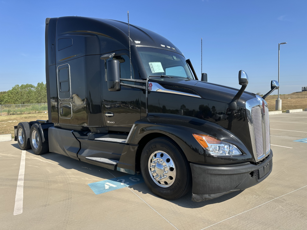 Kenworth T680 highway tractor in black, side view showing cab sleeper, front grille, chrome wheels, and side mirrors.