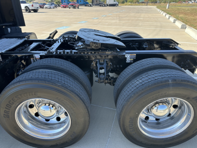 Kenworth T680 wheel area showing dual rear axles and fuel/tractor frame components.