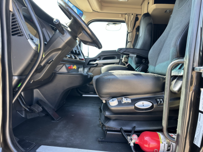 Kenworth T680 truck cab interior showing driver's seat and dashboard with controls, steering wheel, and floor area.
