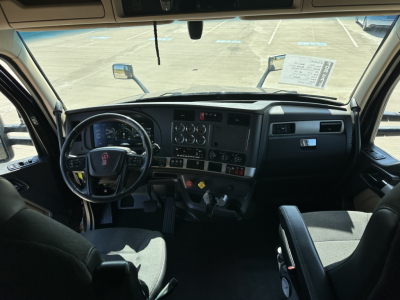 Kenworth T680 truck interior cabin view showing steering wheel, dashboard, and controls.