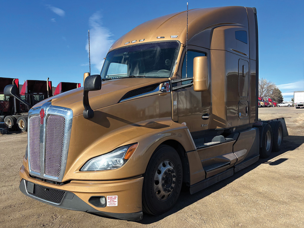 Kenworth T680 Next Gen tractor in tan color, front three-quarter view, showing large chrome grille, aerodynamic hood, dual mirrors, and sleeper cab.
