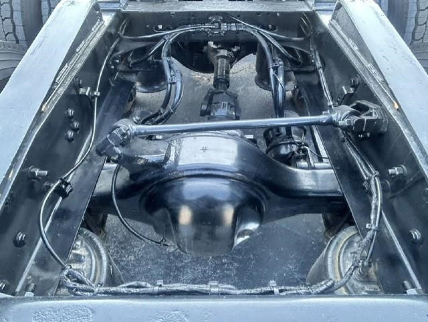 Freightliner Cascadia 126 chassis view showing rear axle differential and drive shaft in a truck bed, with suspension and wiring visible.