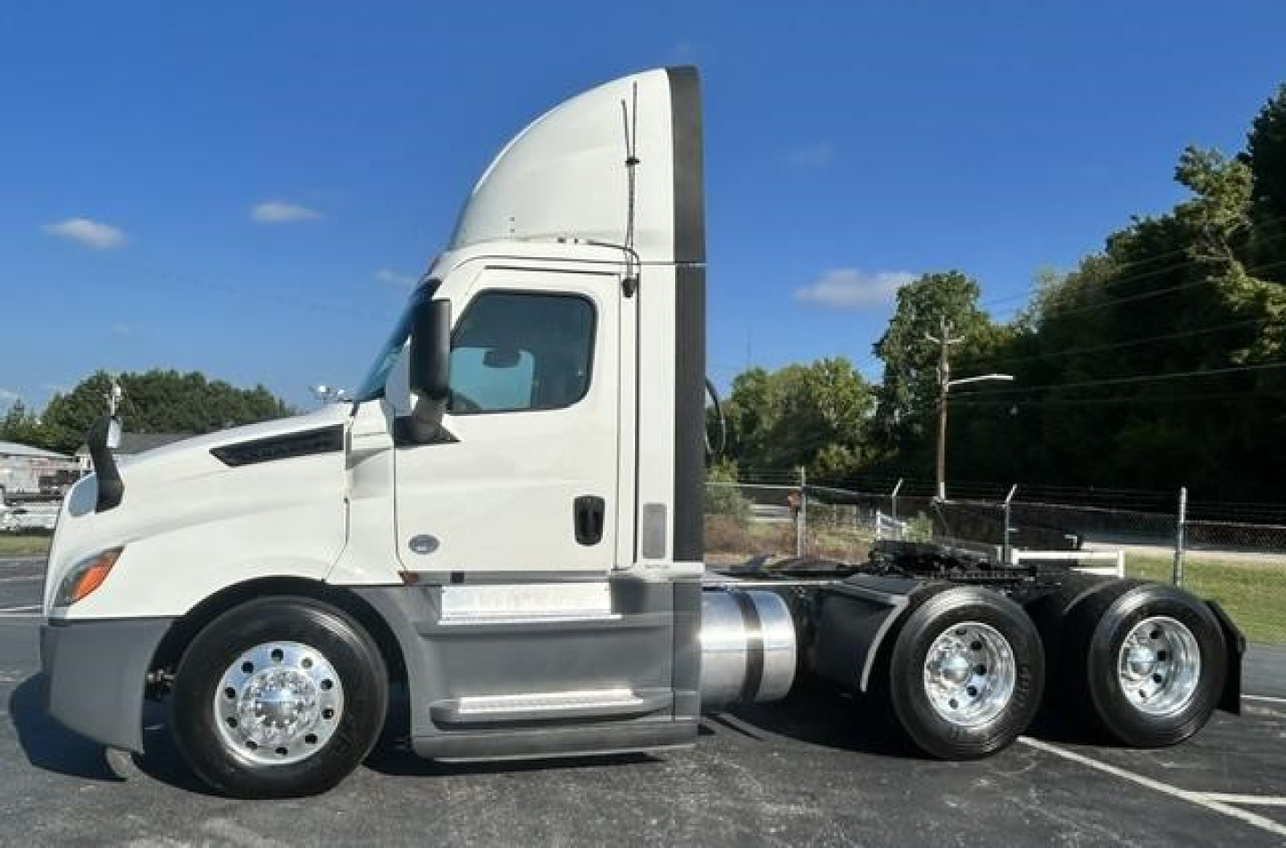 Freightliner Cascadia 126 day cab tractor in-service showing side profile with sleeper cab, chrome wheels, and rear dual axle configuration.