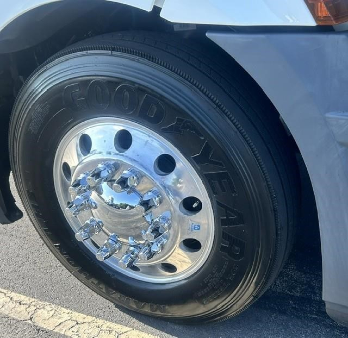 Truck wheel and tire on a Freightliner Cascadia 126 front fender showing Goodyear tire and chrome hubcap.