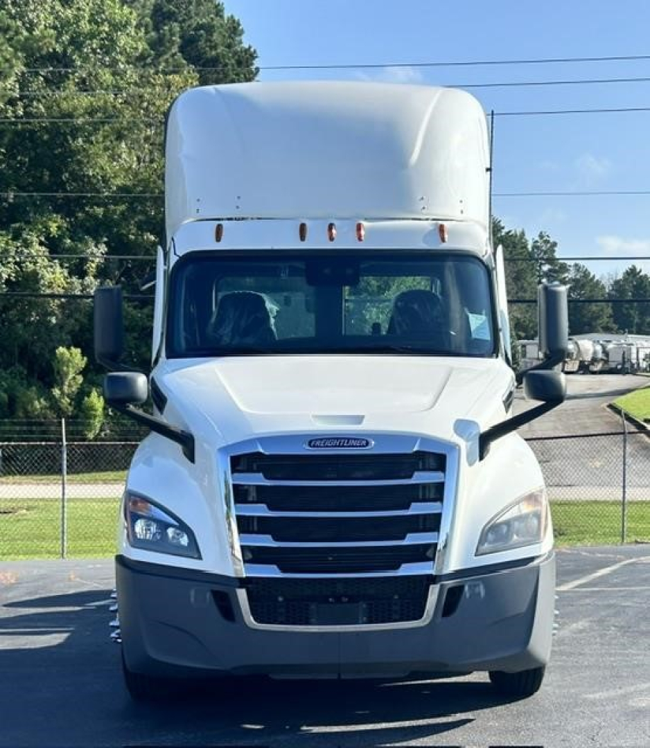 Freightliner Cascadia day cab front view showing grille and headlights with tall sleeper on top.