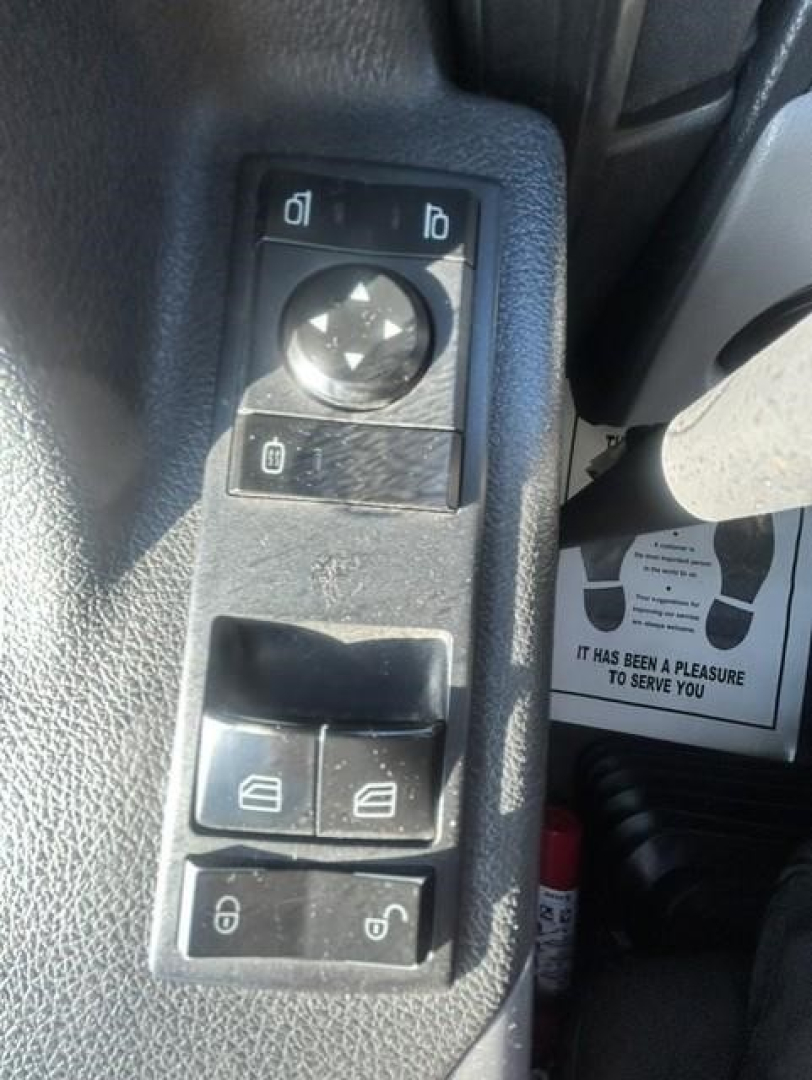 Freightliner Cascadia 126 truck interior window/door panel showing control switches and mirror adjustment knob.