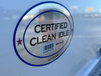 Sticker on Freightliner Cascadia showing Certified Clean Idle, circular blue emblem with barcode in center.
