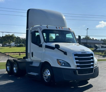 Freightliner Cascadia 126 day cab truck in white, front three-quarter view, with high sleeper, chrome front grille, large mirrors, parked on pavement.