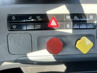 Freightliner Cascadia dashboard control panel showing red hazard button and yellow/right knob with various labeled switches.