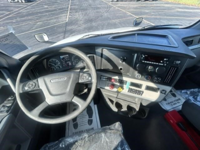 Freightliner Cascadia dashboard and steering wheel showing gauges, control panel, and steering wheel with Freightliner emblem.