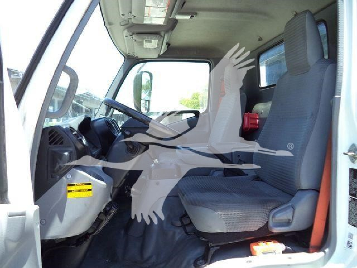 Truck cab interior of a 2020 Hino 195 with grey seats and steering wheel visible