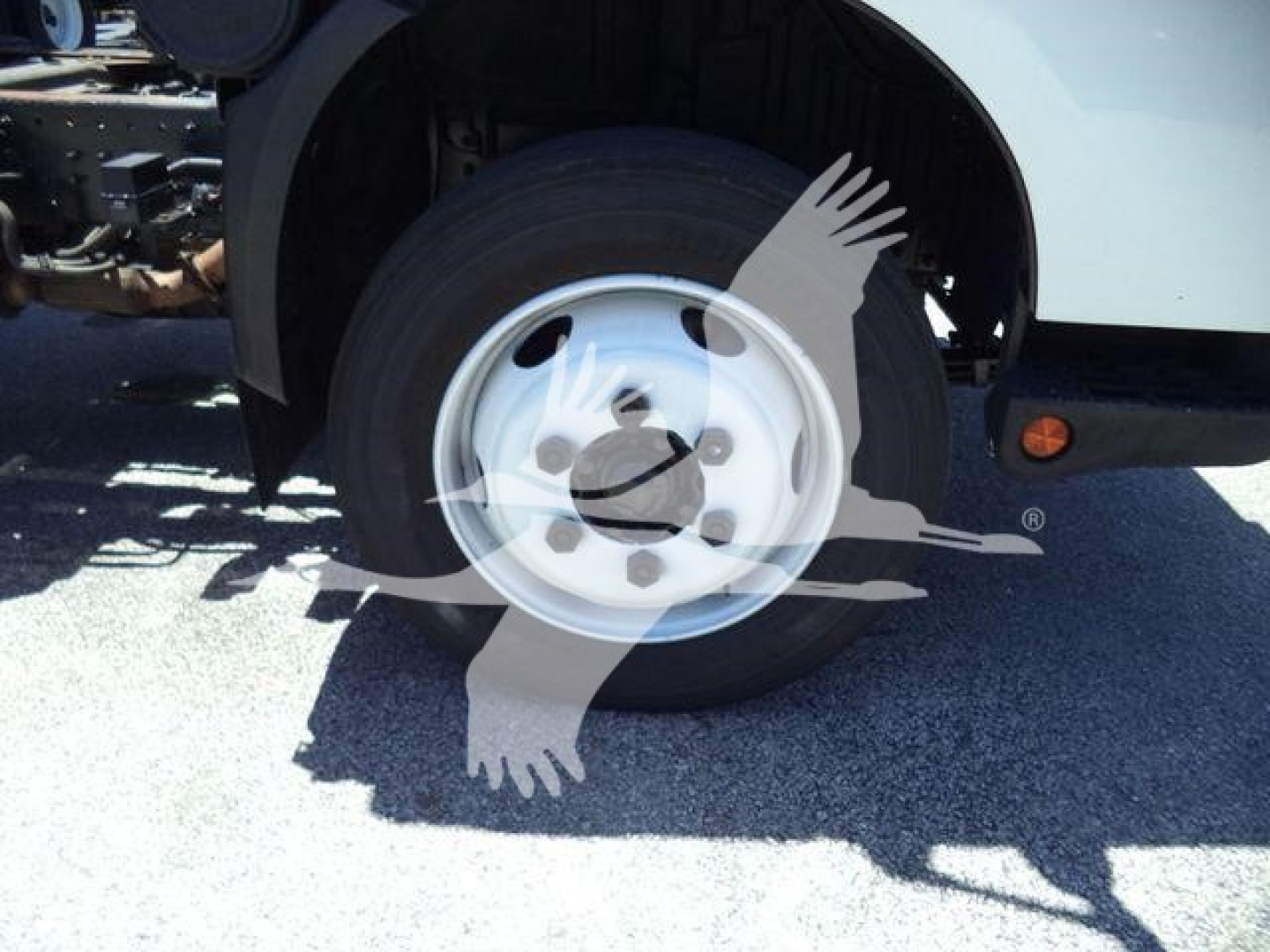Front wheel and fender of a 2020 Hino 195 dump truck showing aluminum wheel and tires.