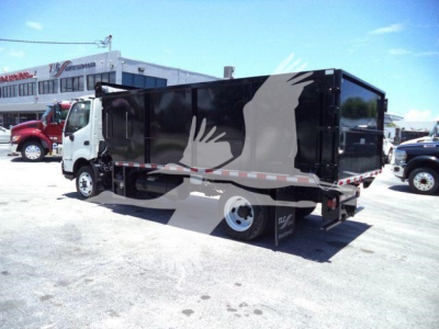 Truck bed side view showing a black dump truck with a white and gray phoenix-like graphic on the cargo body, rear wheels, and reflective stripe.