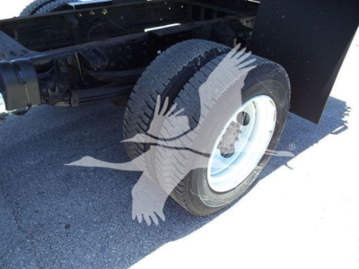 Truck wheel and chassis area of a 2020 Hino 195 dump truck showing the front wheel and suspension.