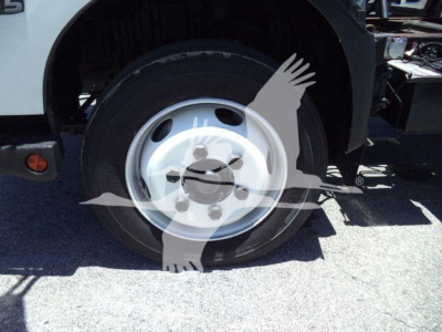 Truck wheel and front fender view showing steel wheel and tire on a 2020 Hino 195 dump truck.