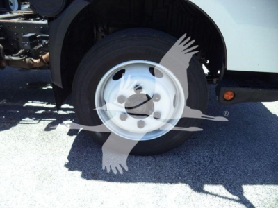 Front wheel and fender of a 2020 Hino 195 dump truck showing aluminum wheel and tires.