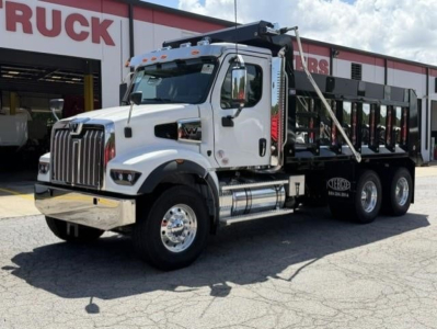Western Star 47X dump truck in white with black dump bed, front chrome bumper, dual rear axles, side steps, and cab-mounted mirrors.