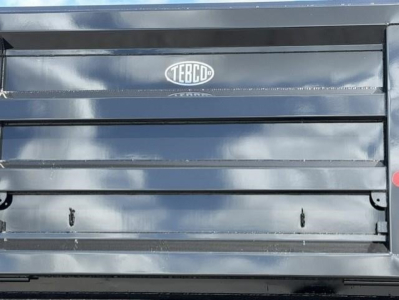 Western Star 47X dump truck bed showing TECD logo on metallic surface and rear tailgate with horizontal ridges.