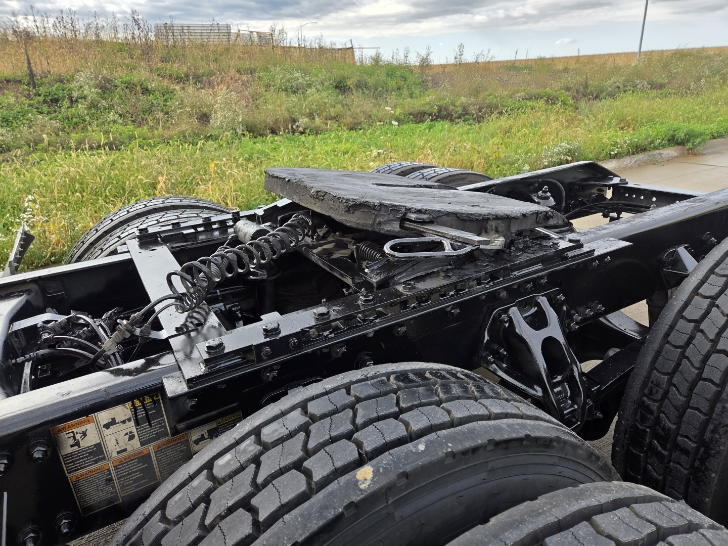 Kenworth T680 chassis showing rear rail and suspension components with tires and frame.