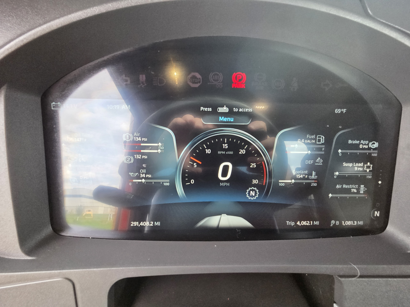 Kenworth T680 digital instrument cluster displaying speedometer at 0 MPH with various gauges and warning icons.