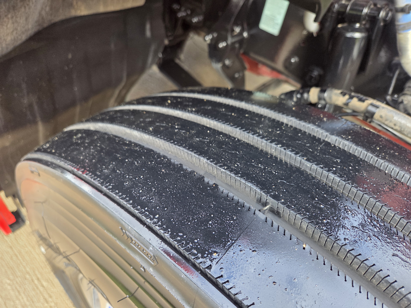 Kenworth T680 wheel and fender area showing large treaded tire and wheel well.