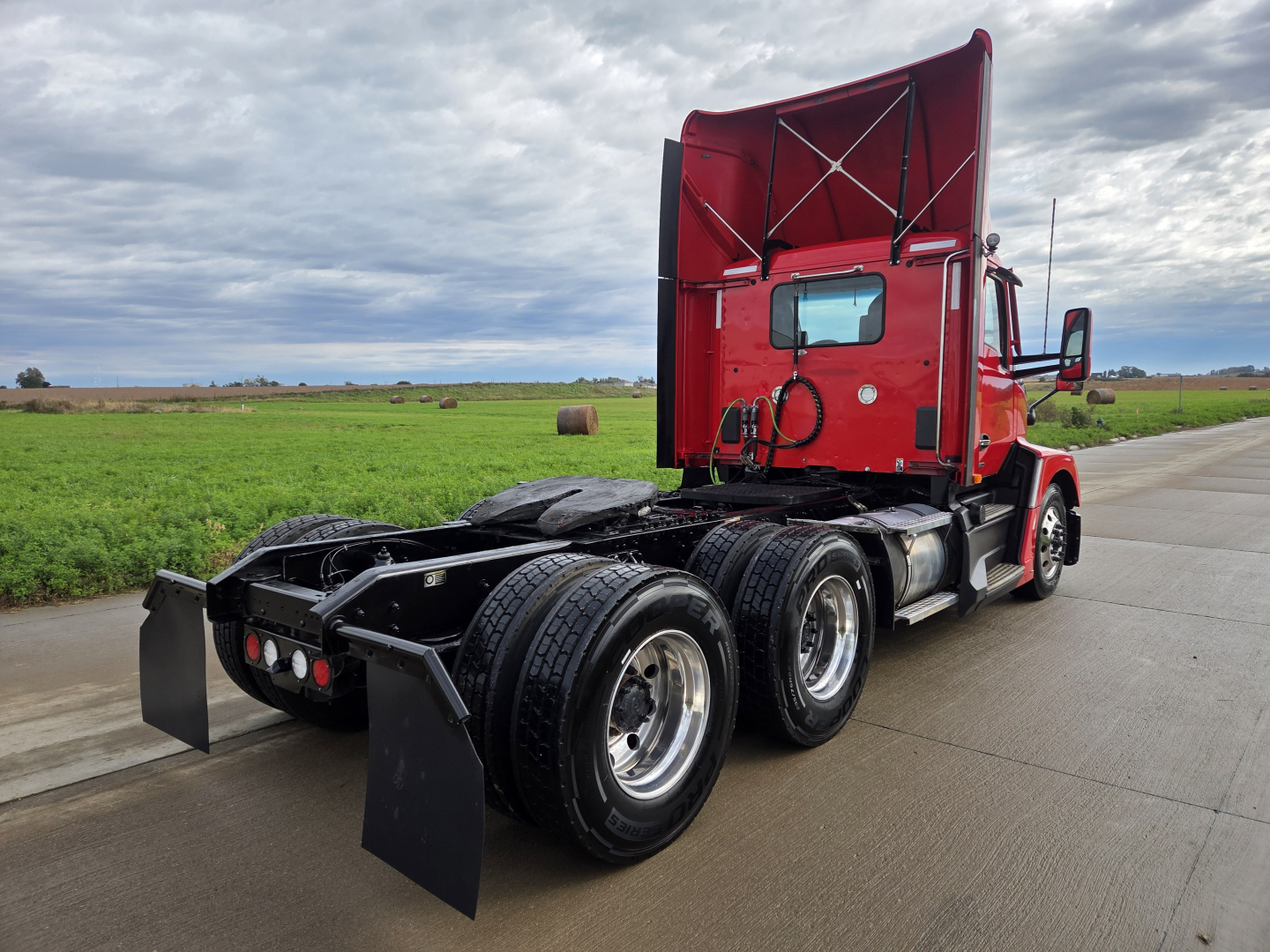 Kenworth T680 tractor rear and cab in red, showing dual rear axles and fifth wheel hitch; no visible text or labels.