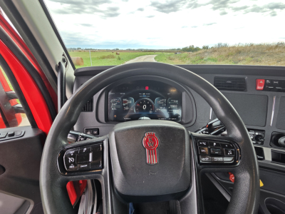 Kenworth T680 cab interior view with steering wheel and dashboard visible; instrument cluster shows digital readouts.