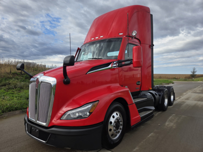 Kenworth T680 daytime cab tractor from front-left view showing red exterior and chrome grille with dual mirrors.