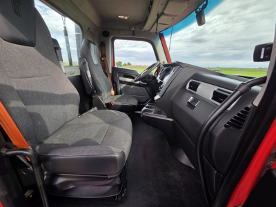 Kenworth T680 interior cab view showing driver seat, dashboard, steering wheel, and front passenger area.