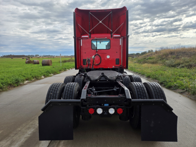 Kenworth T680 truck rear view showing fifth wheel, dual rear axles, and mud flaps.