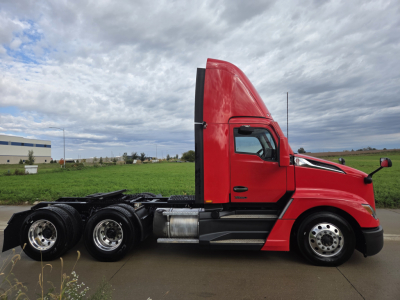 Kenworth T680 tractor-trailer side view showing red cab and black chassis with dual rear axle wheels.