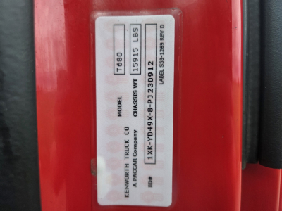 Tag on Kenworth T680 cab showing model, weight, and VIN labels; close-up of vehicle ID plate with text blocks