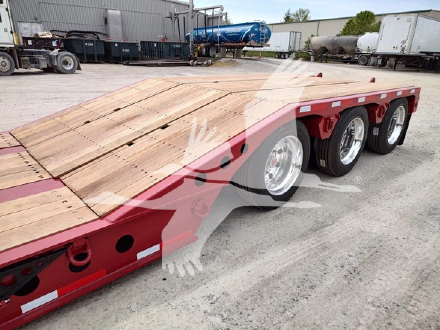  Fontaine Paver Pro lowboy trailer showing wooden deck and triple-axle wheels with red frame