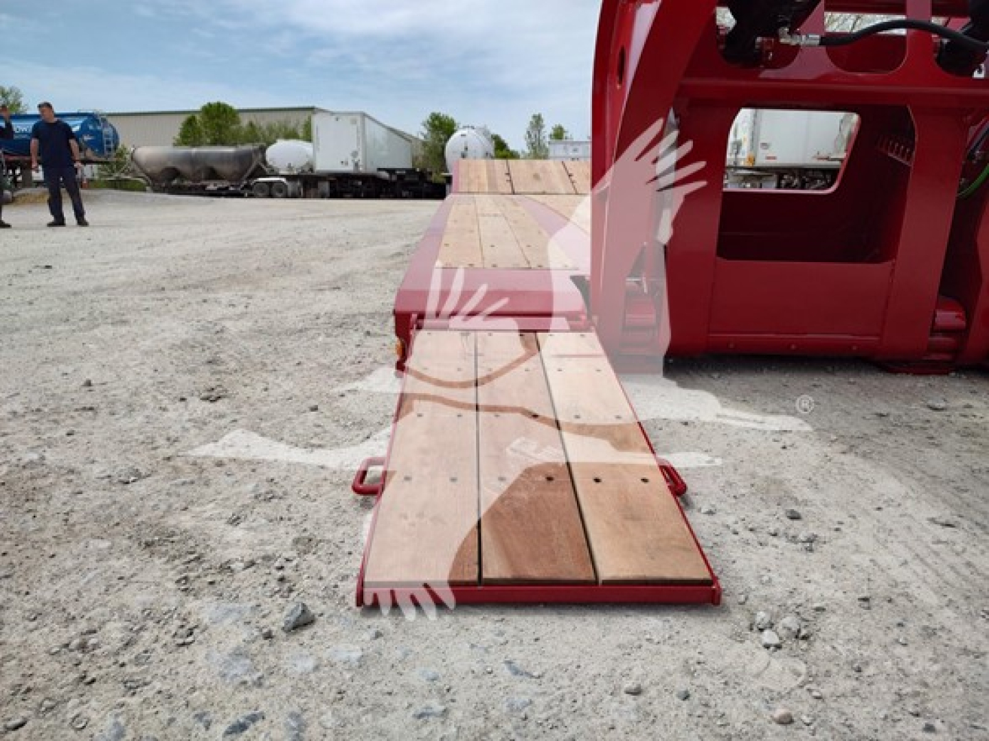  Fontaine Paver Pro lowboy trailer with wooden deck extending from red chassis, outdoor lot, cab and wheel visible in background.