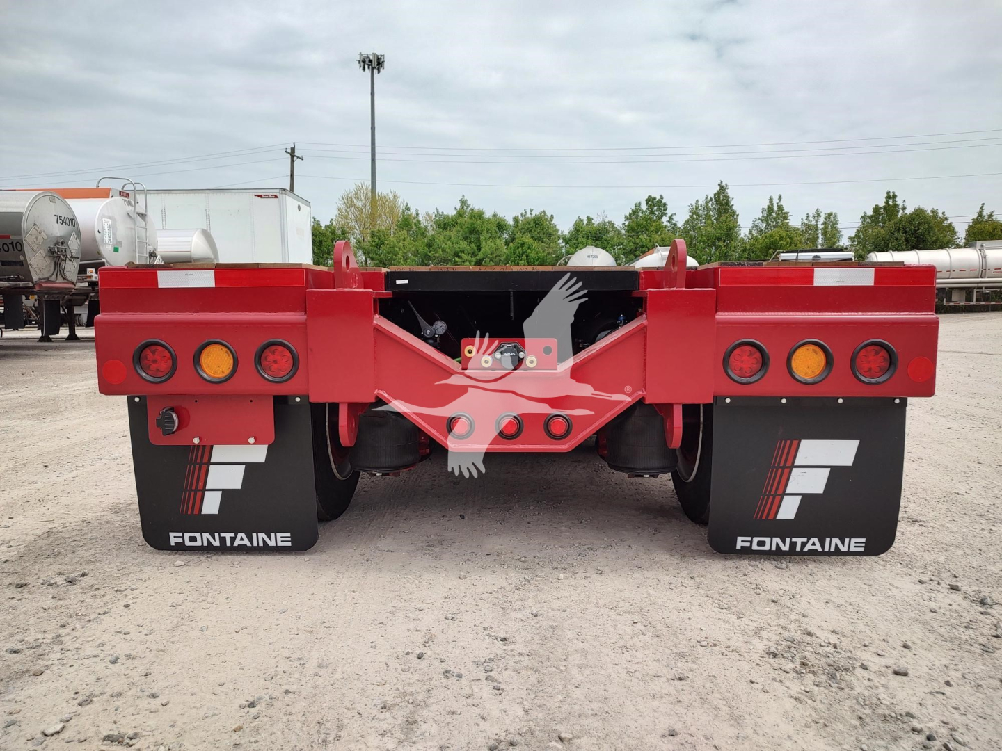 Fontaine paver pro trailer rear view showing red frame, dual axles, and brand mud flaps with Fontaine logo.