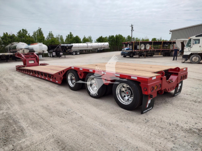 Fontaine Paver Pro lowboy trailer showing dual rear axles and red chassis with wood deck and white reflective tapes.