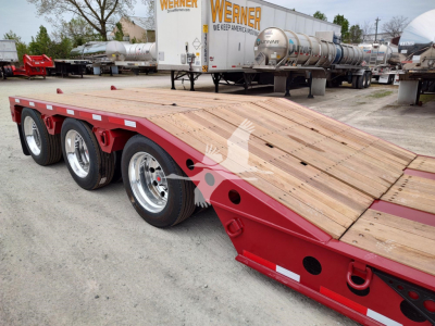  Fontaine Paver Pro lowboy trailer showing wooden deck and red frame with triple-axle configuration.