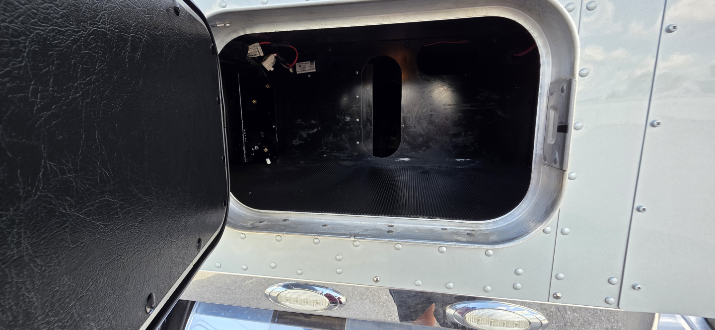 Kenworth truck cab and chassis exterior door opening showing metal surface with rivets and black interior side panel