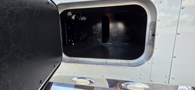 Kenworth truck cab and chassis exterior door opening showing metal surface with rivets and black interior side panel