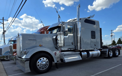 Kenworth W900 cab and chassis truck side view showing chrome fuel tanks and exhaust stacks.