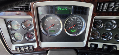 Kenworth W900 dashboard and instrument cluster in view showing gauges and center digital trip info display.