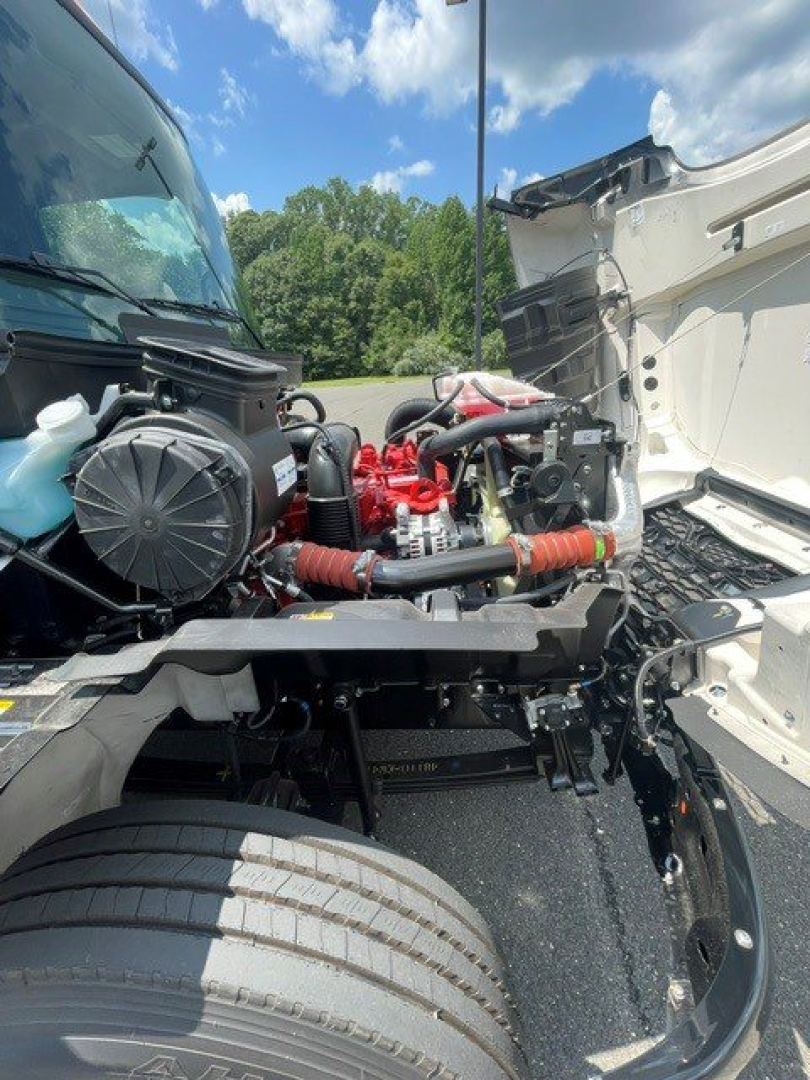 Front engine bay of a 2027 Hino L7 hooklift truck showing exposed red engine components, hoses, and cooling system parts.