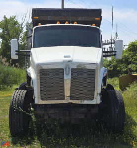 Kenworth T880 dump truck front view showing large chrome grille and dual front tires.