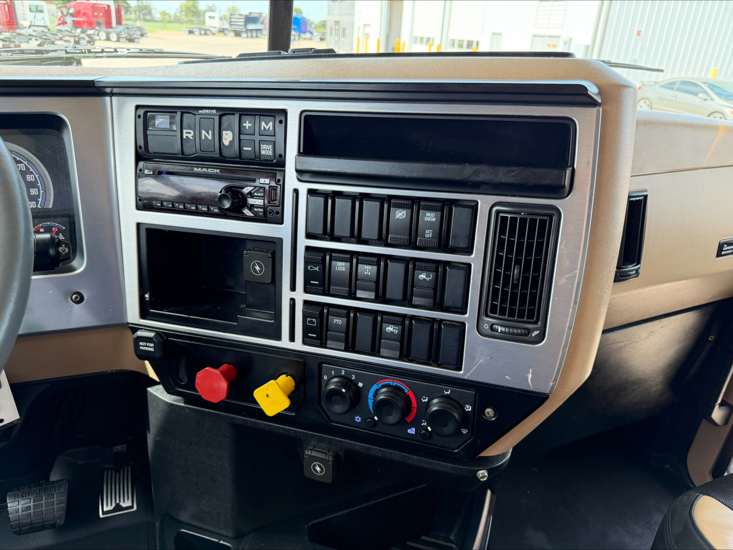 Dashboard of a 2019 Mack PI64T conventional daycab showing control switches, vents, and gauges.