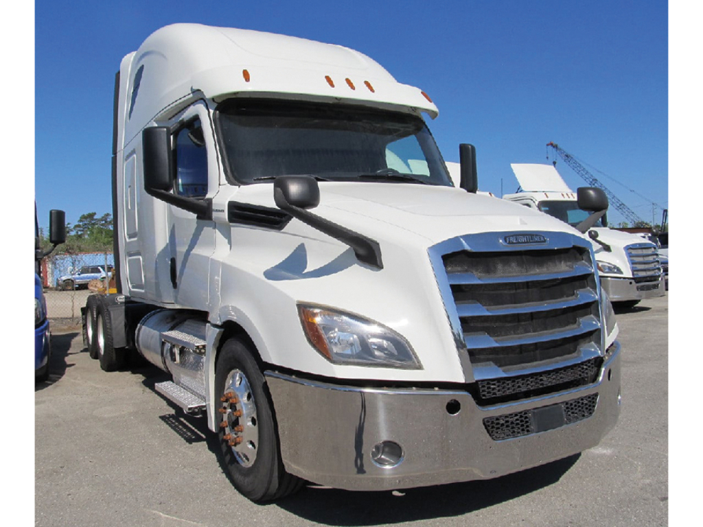 Freightliner Cascadia126 truck in a dealership lot, white cab with blue front grille, chrome bumper, and black mirrors.
