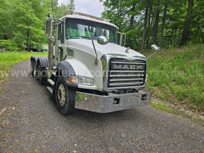 Truck front view showing Mack grille, front bumper, headlights, and side mirrors.