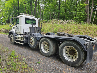 Truck chassis with cab and rear dual rear axles, white Mack GU813 cab, multiple wheels, no visible branding on wheels.