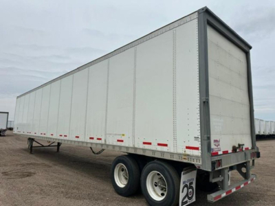 Trailer side view showing a 2016 Wabash van trailer with dual rear axles and grey riveted aluminum sides.