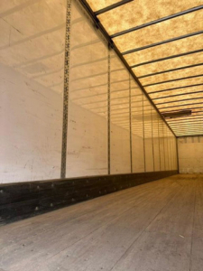 Interior view of a 2016 Wabash van trailer cargo area with aluminum sidewalls, vertical tracking, and wooden flooring.