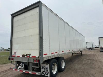 Trailer side view showing a 2016 Wabash van trailer with tandem axles and white exterior panels.